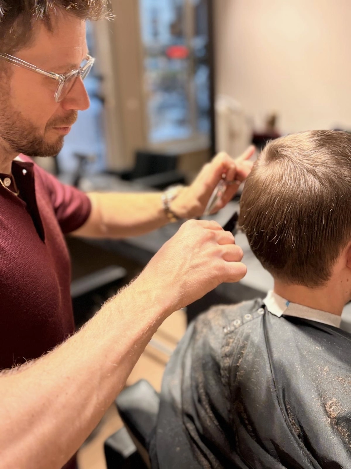 Lukas Ramolla – Friseursalon – Dieses Bild zeigt einen Friseur in Karatschi bei der Arbeit in einem Salon.